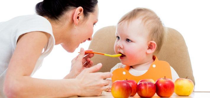 Ребенка кормит мама