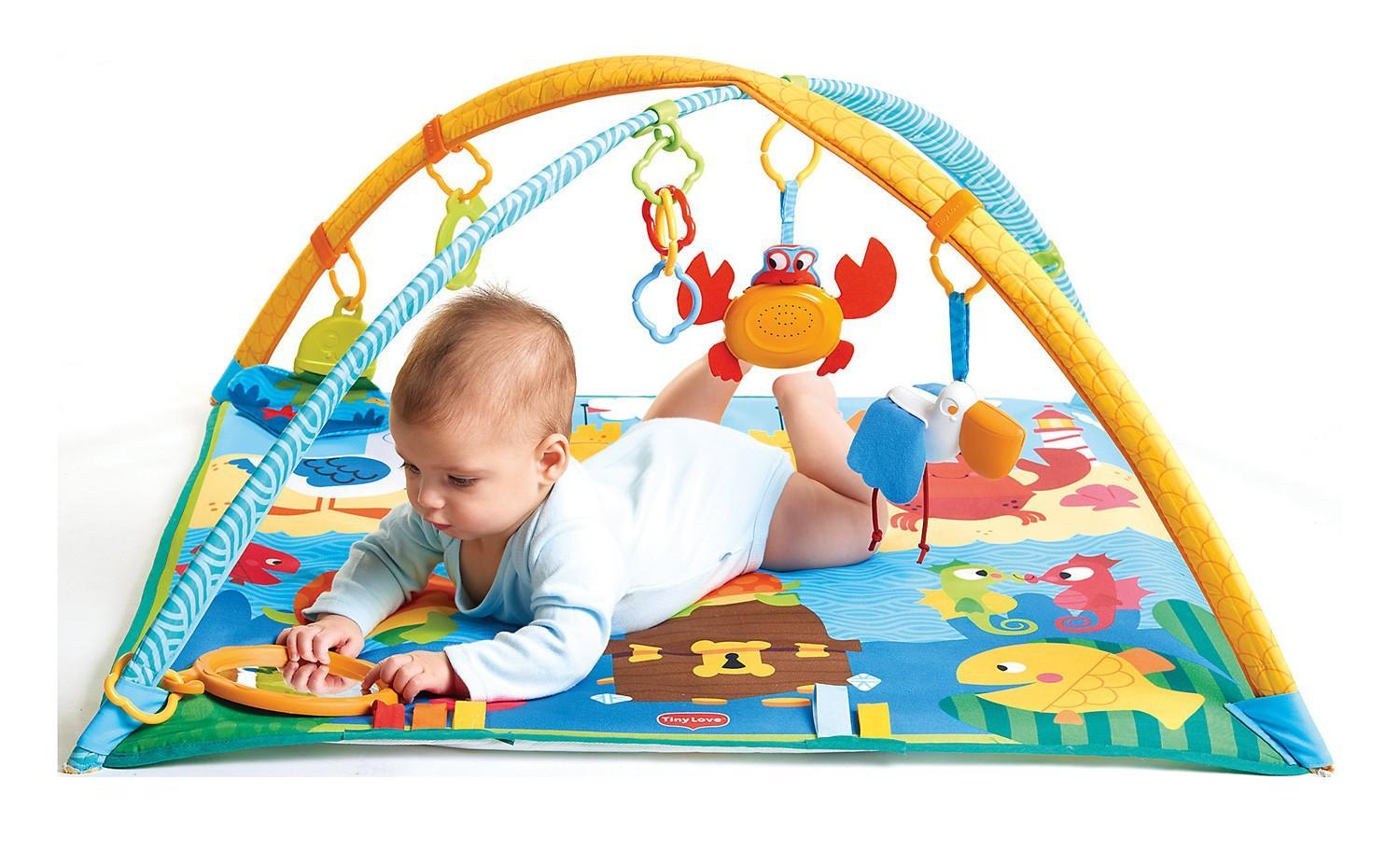 Малыш играет на развивающем коврике