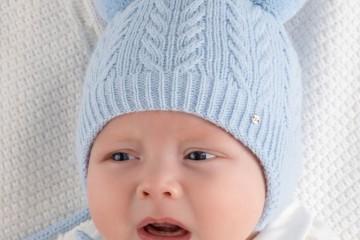 Младенец в шапке с завязками