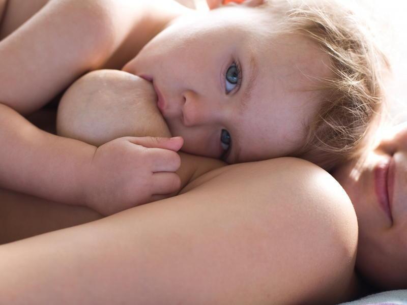 Двухлетний малыш сосет мамину грудь