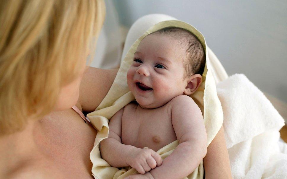 Младенец улыбается маме