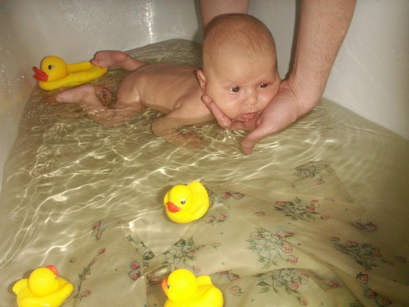 Месячный малыш плавает в ванной